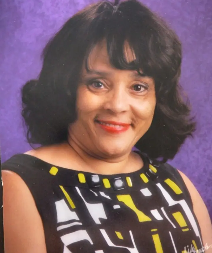 A woman with black hair and yellow and white dress.